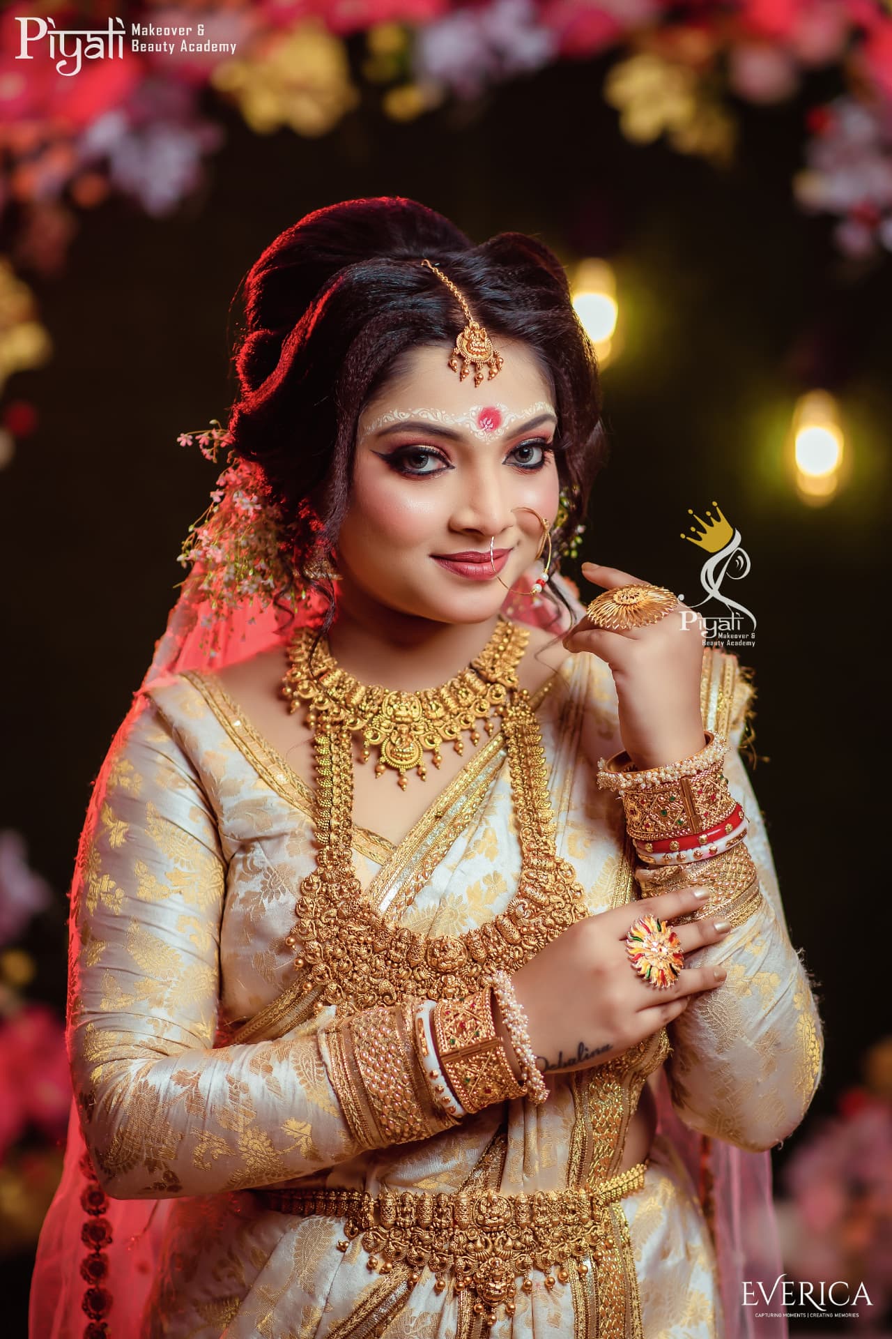 Bride in a cream and gold benarasi adorned with layered gold jewellery